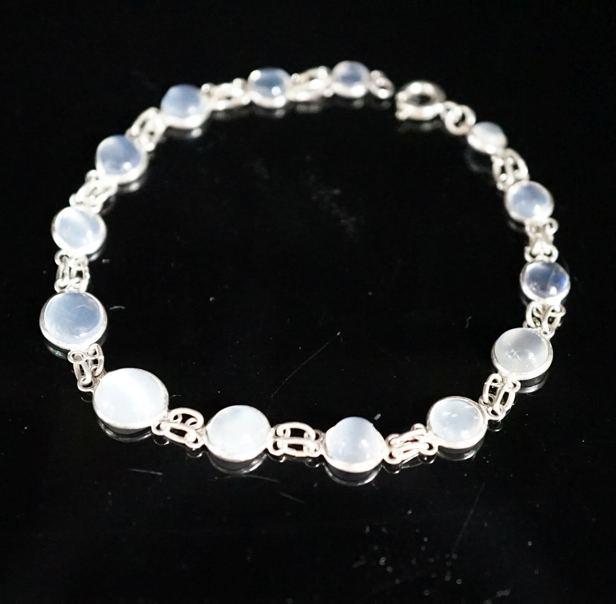 A modern (1980's) white metal and graduated moonstone set bracelet, 17cm.